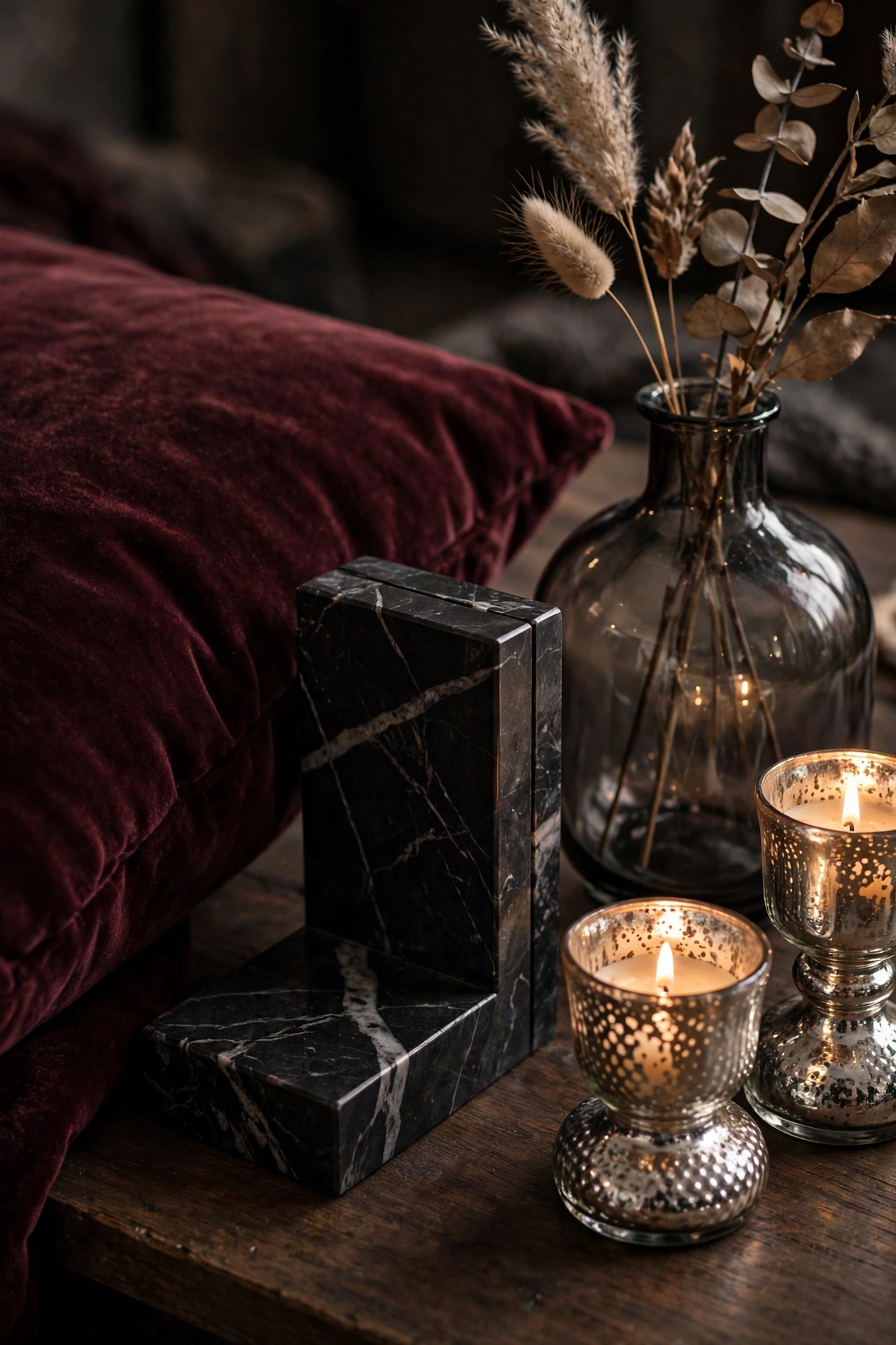 Burgundy velvet cushion, black marble bookend, and mercury-glass candleholders